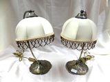 une paire de lampes blanches posées sur une table recouverte d'une nappe blanche