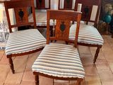 four wooden chairs with striped upholstered seats sit on a tiled floor