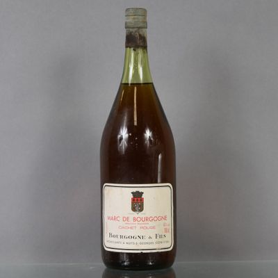 bottles of wine sit on a glass table with a gray background
