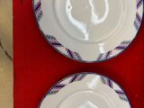 deux assiettes blanches à motifs bleus sur une table rouge