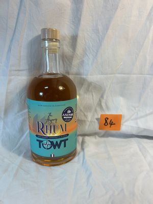 a bottle of rum sitting on a bed with a price tag