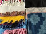 many different colored blankets laid out on the floor