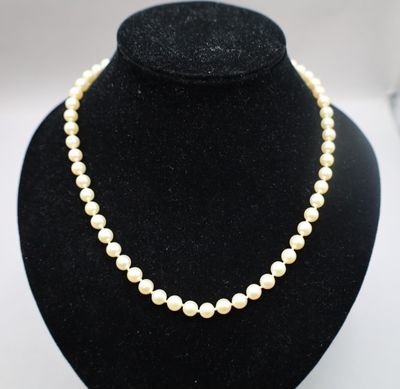 un collier de perles blanches sur un mannequin noir
