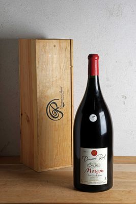 une bouteille de vin posée sur une table à côté d'une caisse en bois