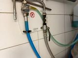 a blue hose attached to a wall next to a water heater