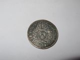a close up of a silver coin on a white surface