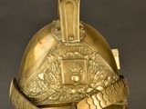 an old helmet with a gold decoration on it on a stand