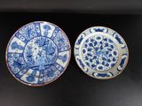 deux assiettes bleues et blanches ornées de motifs, posées sur une surface noire