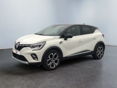 Une voiture blanche est garée dans une pièce au sol noir.