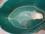 a large green bowl sitting on a white table