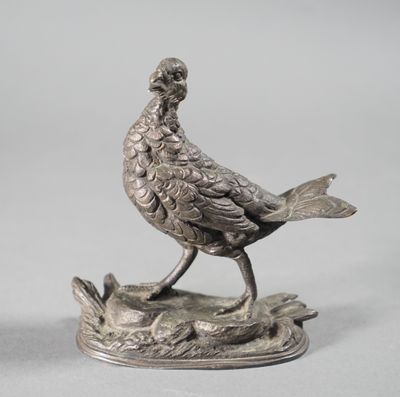 a silver statue of a bird sitting on a tree stump