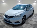 La Nissan Versa blanche est garée dans une pièce au sol carrelé en damier.