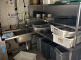 une cuisine équipée d'un évier et de plusieurs poubelles