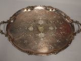an antique silver tray with a design on it on a white surface