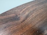 a close up of a wooden table with a white wall in the background
