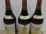 three bottles of wine are lined up on a tile floor