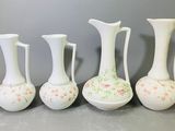 quatre vases blancs posés les uns à côté des autres sur une table