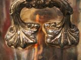 a silver vase that has a handle on it