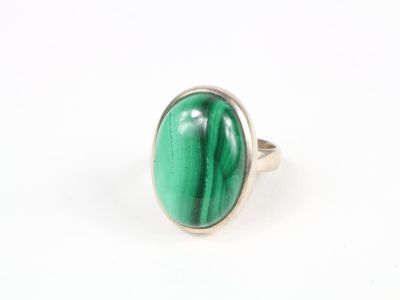 Gros plan sur une bague ornée d'une pierre verte