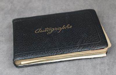 un vieux livre en cuir noir orné d'une inscription dorée