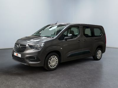 La camionnette grise est garée dans une grande pièce au sol noir.