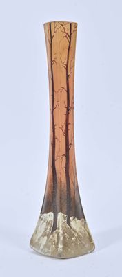 a glass vase with trees on it sitting on a table