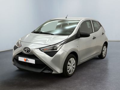 La Toyota AY est garée dans une pièce au sol noir.