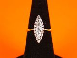 a diamond ring on a black ring stand against an orange background