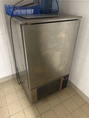 un petit réfrigérateur surmonté d'un panier