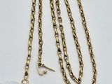 a close up of a gold chain with a tag on it