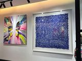 three paintings on the wall of a large room