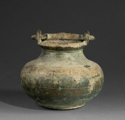 a large green vase sitting on a gray surface