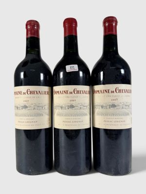 trois bouteilles de vin rouge posées l'une à côté de l'autre sur une surface blanche