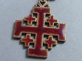 an image of a red and gold cross on a silver chain