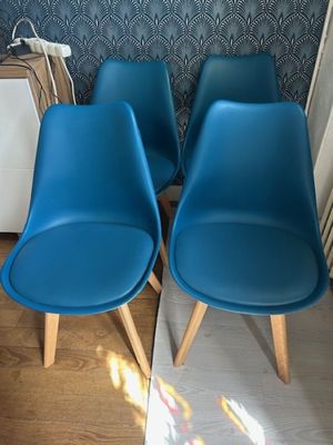 four blue chairs sitting next to each other in a room