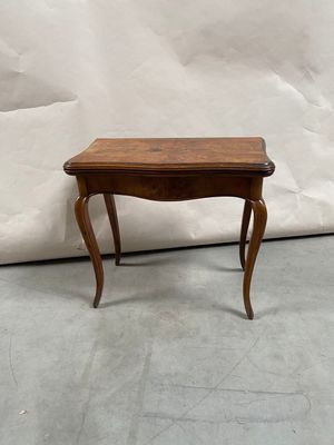 a small table with a wooden top on a cement floor
