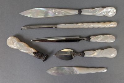 cinq types différents de couteaux et de cuillères disposés sur une table
