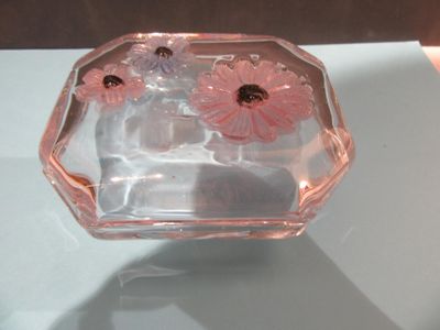 un vase en verre contenant des fleurs roses, posé sur une table
