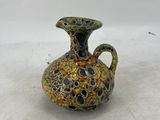 a small vase that is sitting on a white surface