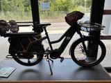 un vélo muni d'un panier à l'arrière, garé devant une fenêtre