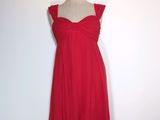 une robe rouge posée sur un présentoir à mannequin, sur fond blanc