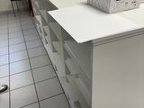 Des cartons sont empilés sur un bureau blanc dans une pièce