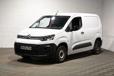 la camionnette blanche est garée dans une grande pièce au sol en damier