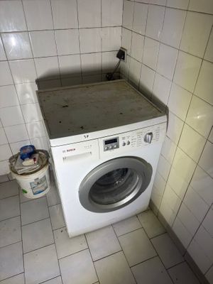 a washer and dryer in the corner of a tiled room