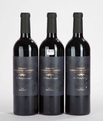trois bouteilles de vin rouge posées sur une table blanche
