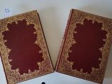 two old books sitting on a table next to each other