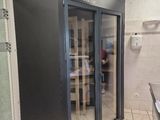 a bathroom with a glass door and a tiled floor
