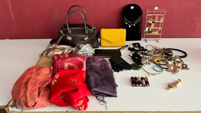 une table sur laquelle sont posés de nombreux sacs à main et d'autres objets