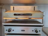 a stove that has a pizza on top of it