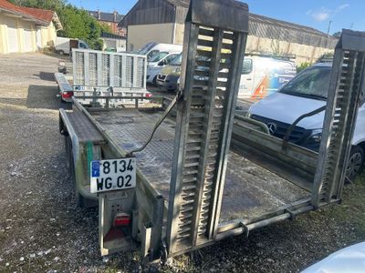 une photo d'une remorque à plateau garée sur un parking